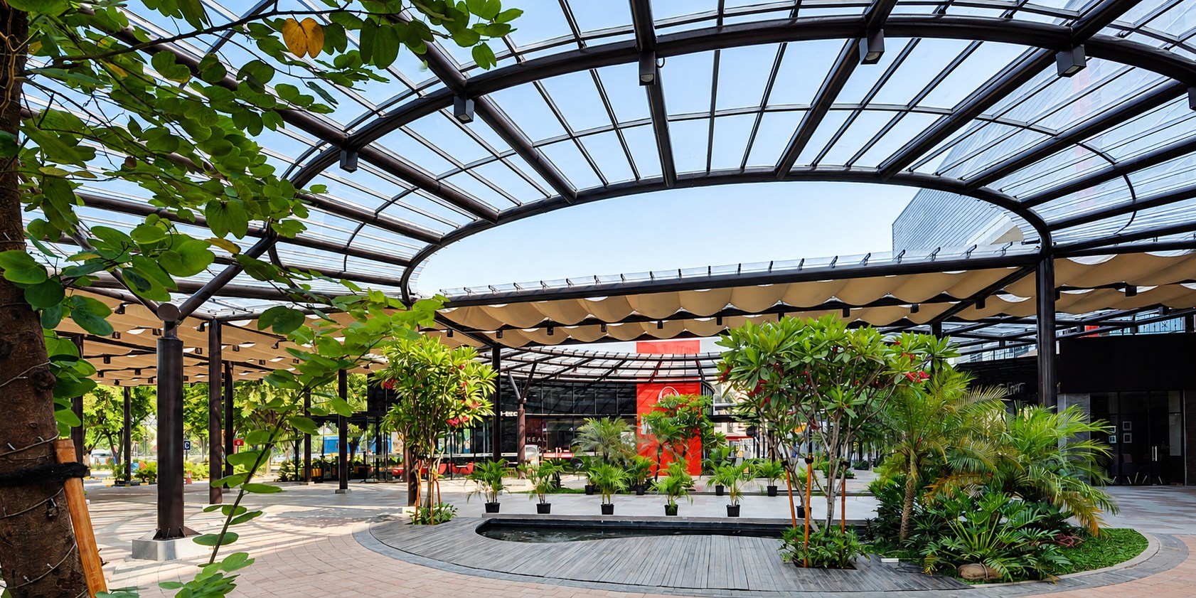 SolarFlat polycarbonate canopy over a landscaped mall garden courtyard